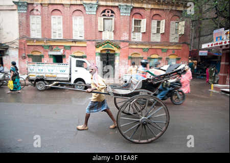 L'exécution de rickshaw wallah hors belle vieille époque Raj Calcutta Kolkata en bâtiment backstreet, Bengale occidental, Inde, Asie Banque D'Images