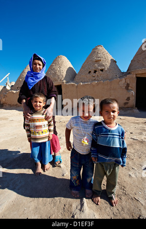 Famille en face de la ruche d'Harran maisons d'adobe, au sud-ouest de l'Anatolie, la Turquie. Banque D'Images