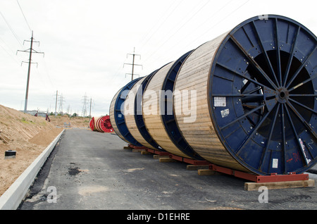 Bobines de câbles haute tension en face du site de construction de la ligne d'alimentation. La construction de routes et d'électricité travaux de pose de ligne de métro. Banque D'Images