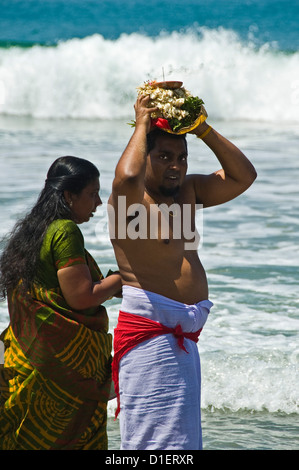 Portrait vertical d'un indien et d'une femme effectuant puja (prière) sur la plage de Varkala, Kerala. Banque D'Images