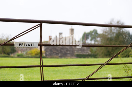 Panneau privé peint en blanc sur le fer metal ferme sur le terrain avec le gîte à la ferme à distance Banque D'Images