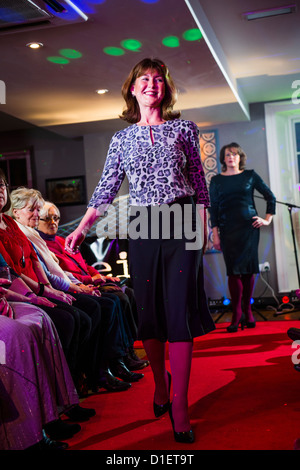 Non professionnels, amateurs de modélisation des femmes fashion vêtements sur un podium, la charité Cancer Research UK, soirée de collecte de fonds Banque D'Images