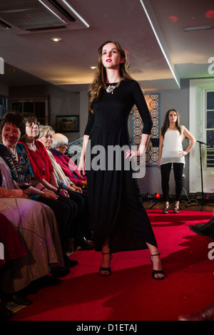 Non professionnels, amateur femmes vêtements de mode de modélisation sur un catwalk show, la charité Cancer Research UK, soirée de collecte de fonds Banque D'Images