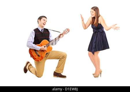 Un homme jouant sur une guitare et chanter à son amie contre isolé sur fond blanc Banque D'Images