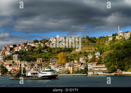 Bateau de pêche à la senne sur le détroit du Bosphore avec des maisons sur la colline à Yeni Mahalle Sariyer Turquie Banque D'Images