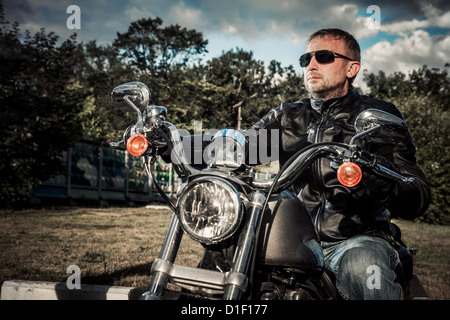 Biker homme est assis sur un vélo Banque D'Images