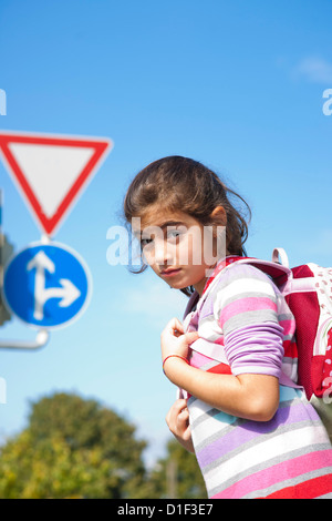 Girl standing in front of traffic sign Banque D'Images