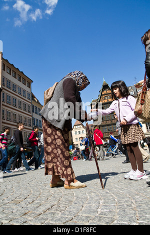 Vieille Femme mendiant sur la place de la cathédrale à Strasbourg, France Banque D'Images