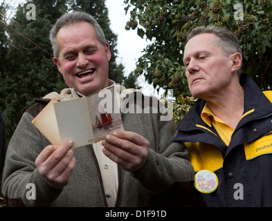 Engelbert Bergmann (R) lecture d'une carte postale sur le terrain de 1941 prononcé par postman Klaus Kaiser (R) dans la région de Muehlheim, Allemagne, 18 décembre 2012. La carte de Noël de Bergmann adressée à grand-père de voisine et soldat allemand Emil Adam, qui était stanioned sur l'île anglo-normande de Jersey, a été prise par un groupe de jeunes combattants resistantance. Il a été rendu à la Jersey poster 70 ans plus tard. Photo : FRANK RUMPENHORST Banque D'Images