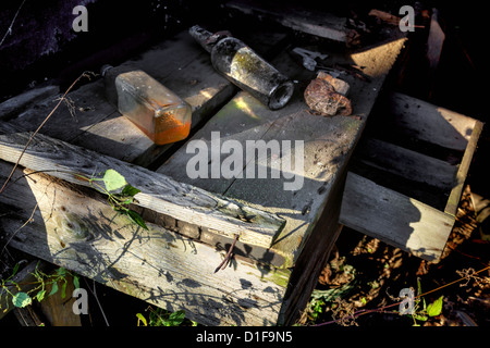 Bouteilles sur un banc dans un bâtiment abandonné Banque D'Images