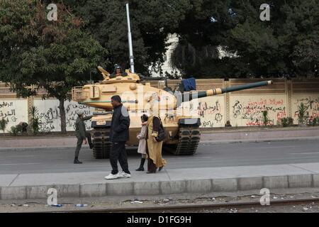 19 déc., 2012 - Le Caire, Le Caire, Égypte - égyptiens à pied passer le fil barricade comme soldats de l'armée égyptienne et la protection des réservoirs au Caire palais présidentiel le 19 décembre 2012. Les opposants du Président égyptien Mohamed Morsi ont manifesté au Caire le mardi contre un projet de constitution soutenu par les islamistes qui a divisé l'Égypte mais semble devoir être approuvée dans la deuxième moitié de ce week-end un référendum (crédit Image : © Ashraf Amra/APA Images/ZUMAPRESS.com) Banque D'Images