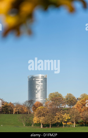 Posttower, la siège de Deutsche Post DHL à Bonn, vu du parc de loisirs Rheinaue, encadrée par des feuilles d'automne Banque D'Images