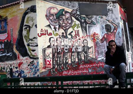 19 déc., 2012 - Le Caire, Le Caire, Égypte - un siège égyptien au palais présidentiel et anti-Morsi graffiti est visible sur le mur du palais derrière lui au Caire, 18 décembre 2012. L'opposition de l'Egypte ont organisé des rassemblements dans tout le pays mardi pour protester contre le projet de constitution référendum, après le ministère de la Justice a ordonné une enquête sur les allégations d'irrégularités de vote au cours du samedi premier tour de scrutin sur le document (Image Crédit : © Ashraf Amra/APA Images/ZUMAPRESS.com) Banque D'Images