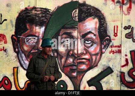 19 déc., 2012 - Le Caire, Le Caire, Égypte - Un soldat de la garde républicaine monte la garde au palais présidentiel et anti-Morsi graffiti est visible sur le mur du palais derrière lui au Caire, 18 décembre 2012. L'opposition de l'Egypte ont organisé des rassemblements dans tout le pays mardi pour protester contre le projet de constitution référendum, après le ministère de la Justice a ordonné une enquête sur les allégations d'irrégularités de vote au cours du samedi premier tour de scrutin sur le document (Image Crédit : © Ashraf Amra/APA Images/ZUMAPRESS.com) Banque D'Images