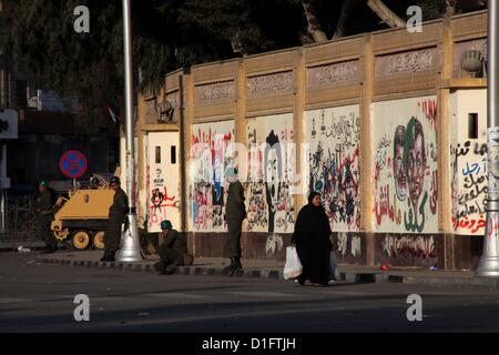 19 déc., 2012 - Le Caire, Le Caire, Égypte - égyptiens à pied passer le fil barricade comme soldats de l'armée égyptienne et la protection des réservoirs au Caire palais présidentiel le 19 décembre 2012. Les opposants du Président égyptien Mohamed Morsi ont manifesté au Caire le mardi contre un projet de constitution soutenu par les islamistes qui a divisé l'Égypte mais semble devoir être approuvée dans la deuxième moitié de ce week-end un référendum (crédit Image : © Ashraf Amra/APA Images/ZUMAPRESS.com) Banque D'Images