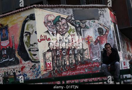 19 déc., 2012 - Le Caire, Le Caire, Égypte - un siège égyptien au palais présidentiel et anti-Morsi graffiti est visible sur le mur du palais derrière lui au Caire, 18 décembre 2012. L'opposition de l'Egypte ont organisé des rassemblements dans tout le pays mardi pour protester contre le projet de constitution référendum, après le ministère de la Justice a ordonné une enquête sur les allégations d'irrégularités de vote au cours du samedi premier tour de scrutin sur le document (Image Crédit : © Ashraf Amra/APA Images/ZUMAPRESS.com) Banque D'Images