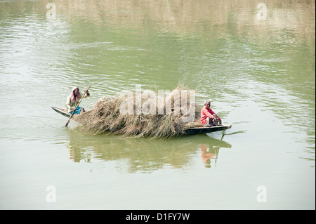 Bateau en bois pagaie bateliers laden avec de la paille de l'autre côté de la rivière Hugli (rivière Hooghly), communauté rurale de l'Ouest Bengale, Inde, Asie Banque D'Images