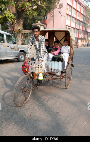 Pousse-pousse à vélo en prenant les enfants à l'école, Chandernagar, Bengale occidental, Inde, Asie Banque D'Images