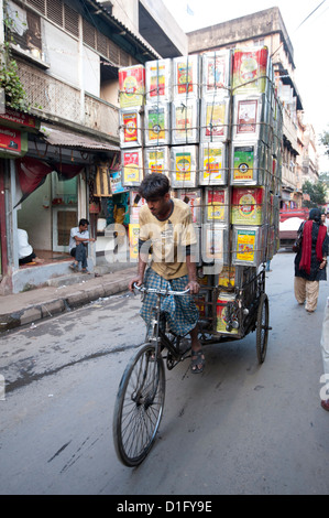 L'exécution de pousse-pousse Cycle énorme charge de bidons d'huile par l'intermédiaire de marché, Kolkata (Calcutta), West Bengal, Inde, Asie Banque D'Images