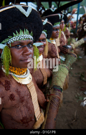 Habillés de couleurs vives et le visage peint les tribus locales pour célébrer la traditionnelle chanter chanter dans les Highlands, la Papouasie-Nouvelle-Guinée Banque D'Images