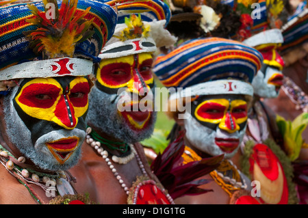 Habillés de couleurs vives et le visage peint les tribus locales pour célébrer la traditionnelle chanter chanter dans les Highlands, la Papouasie-Nouvelle-Guinée Banque D'Images