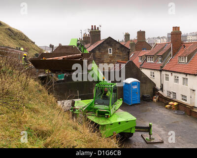 Les entrepreneurs qui travaillent rapidement pour stabiliser la pente raide au-dessous de l'église St Mary à Whitby. Forte pluie risque de provoquer un glissement de mettre en danger les maisons et fortune célèbre Kipper smokery dans Henrietta Street, à Whitby, North Yorkshire UK. Henrietta Street, à Whitby, North Yorkshire UK. Au-dessous de propriétés ont été évacués par mesure de précaution. © Peter Jordan NE / Alamy Live News Banque D'Images