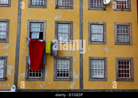 Blanchisserie colorée accrochée à une fenêtre d'appartement sur la rue de la ville à Porto Portugal Banque D'Images