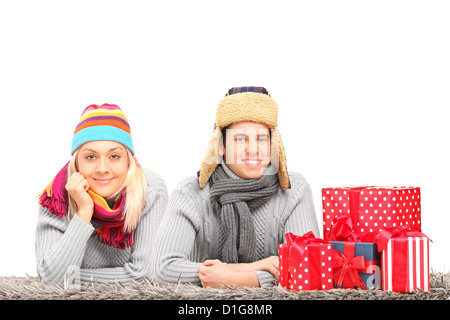 Un couple heureux avec des chapeaux et neckwears allongé sur un tapis près de présente isolé sur fond blanc Banque D'Images