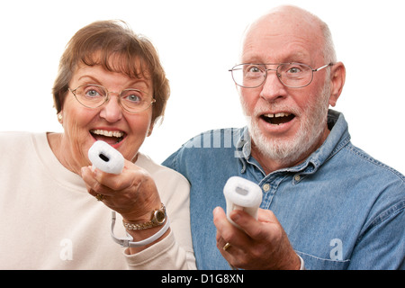 Happy Senior Couple jouer jeu vidéo avec des commandes à distance sur un fond blanc. Banque D'Images