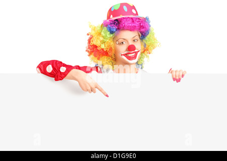 Avec happy clown femelle expression joyeuse pointant avec le doigt sur un panneau vide isolé sur fond blanc Banque D'Images