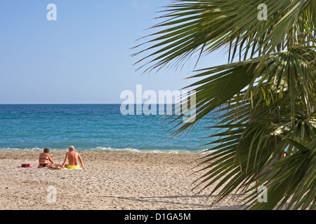 Middle aged couple enjoying sun sur la plage de Burriana, Nerja, Espagne Banque D'Images