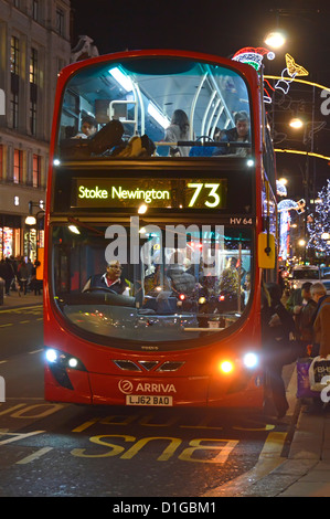 Bus à impériale de Londres à l'arrêt de bus d'embarquement shoppers nuit Banque D'Images