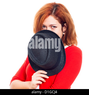 Jeune femme secret se cachant derrière hat, isolé sur fond blanc. Banque D'Images