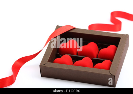 Coeur rouge en boîte marron sur fond blanc Banque D'Images