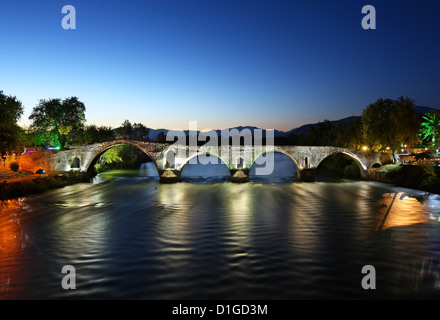 Vue nocturne de la légendaire vieux pont voûté en pierre d'Arta, en traversant la rivière Arachtos. L'Épire, Grèce Banque D'Images