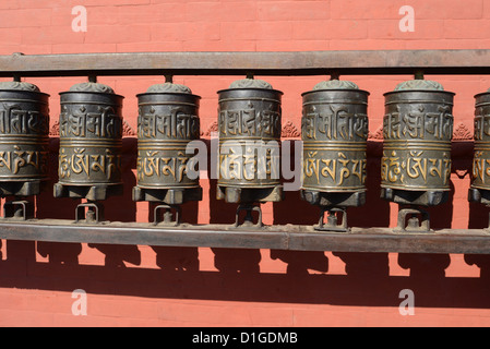 La prière bouddhiste se fait devant un mur rouge à Swayambhunath Stupa, Temple des singes, Katmandou Népal Banque D'Images