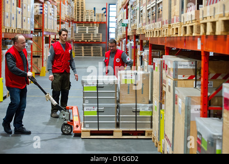 Les employés de la Croix-Rouge allemande travaillent au centre logistique de la Croix-Rouge allemande en Schönefeld, Allemagne, 19 décembre 2012. Un vol avec l'aide de colis est censée commencer à partir de l'aéroport de Berlin-Schoenefeld à Damas en Syrie dans la nuit du 19 au 20 décembre 2012. Croix-rouge allemande est la seule organisation de secours qui peut fonctionner à travers la Syrie et coopère closesly avec le Croissant-Rouge syrien. Photo : PATRICK PLEUL Banque D'Images