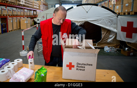 Un employé de la Croix Rouge allemande montre le contenu d'un colis d'aide d'hygiène pour les familles syriennes au centre logistique de la Croix-Rouge allemande en Schönefeld, Allemagne, 19 décembre 2012. Un vol avec l'aide de colis est censée commencer à partir de l'aéroport de Berlin-Schoenefeld à Damas en Syrie dans la nuit du 19 au 20 décembre 2012. Croix-rouge allemande est la seule organisation de secours qui peut fonctionner à travers la Syrie et coopère closesly avec le Croissant-Rouge syrien. Photo : PATRICK PLEUL Banque D'Images