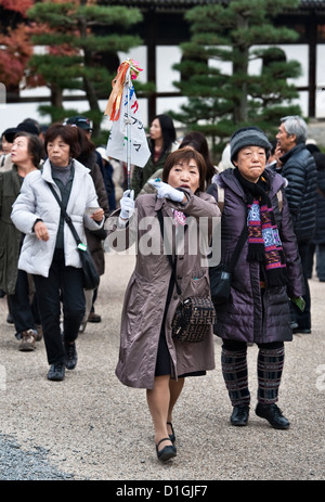 Un guide de tourisme féminin conduit un groupe touristique à visiter Tofuku-ji, Kyoto, Japon, un endroit célèbre et populaire pour voir le feuillage d'automne, ou koyo Banque D'Images