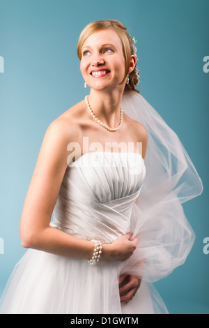 Belle mariée robe de mariage blanc, fond bleu Banque D'Images