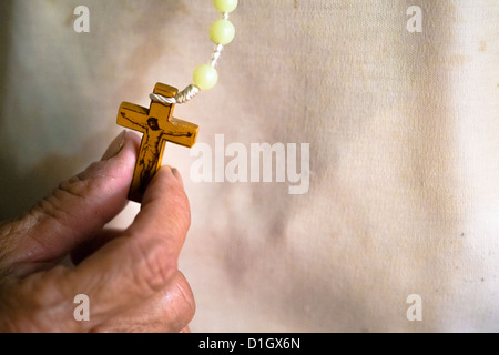 Image en couleur d'une vieille femme tenant un crucifix dans sa main Banque D'Images