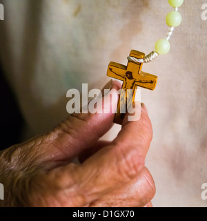 Image en couleur d'une vieille femme tenant un crucifix dans sa main Banque D'Images