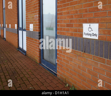 2012 décembre - panneau de stationnement pour personnes handicapées sur un petit mur de bureau. Banque D'Images