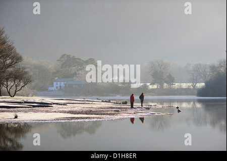 Les promeneurs sur la rive du Derwent Water dans le district du lac en hiver. Banque D'Images