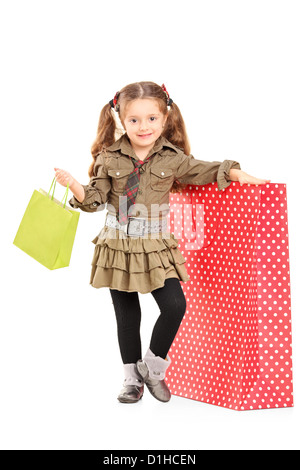 Portrait d'une jeune fille à côté d'un sac shopping isolé sur fond blanc Banque D'Images
