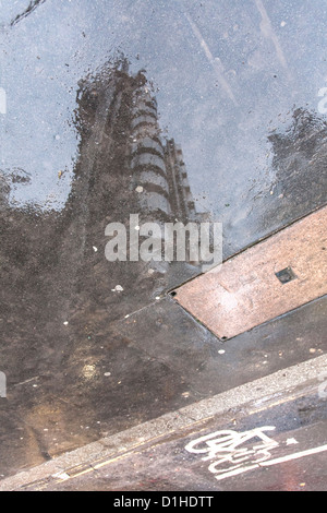 Reflet de Lloyd's Building in puddle un jour de pluie dans la ville de Londres Banque D'Images