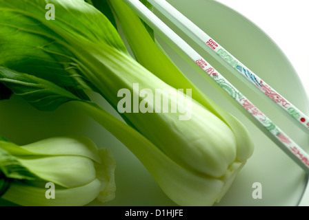 Un close up image de la matières vert feuilles de Pak-choï dans un bol avec des baguettes Banque D'Images