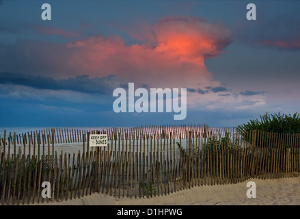 Scène d'une soirée à la plage. Les derniers rayons de lumière éclairage radicalement les nuages dans le ciel d'un orage à proximité. Banque D'Images