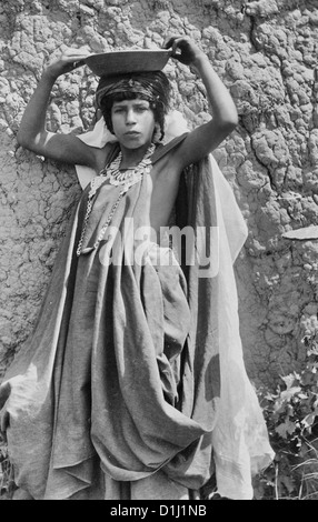 Jeune fille, portrait en pied, debout, face à face, portant des coins necklace, holding de tête, Algérie, circa 1880 Banque D'Images