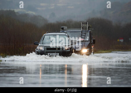 Derwenlas Ceredigion, pays de Galles au Royaume-Uni. Lundi 24 décembre 2012. Les voitures qui circulent dans les eaux de l'A487 Trunk road à Derwenlas, Ceredigion, près de Machynlleth. En dépit de la route d'être officiellement fermé encore la circulation a tenté de négocier la route, avec un peu de se coincer dans l'eau. Photo : Keith Morris/Alamy Live News Banque D'Images